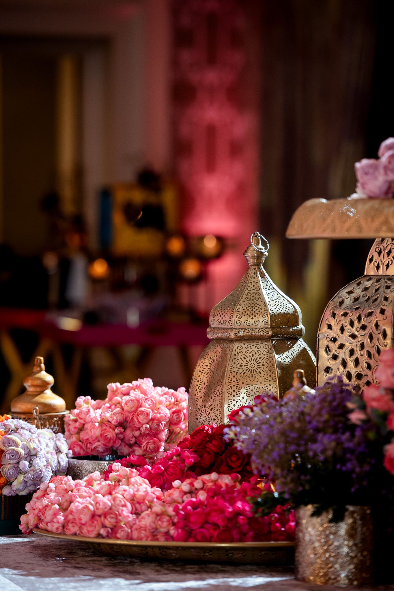 Decorative lantern and pink floral arrangements creating an elegant wedding table display.