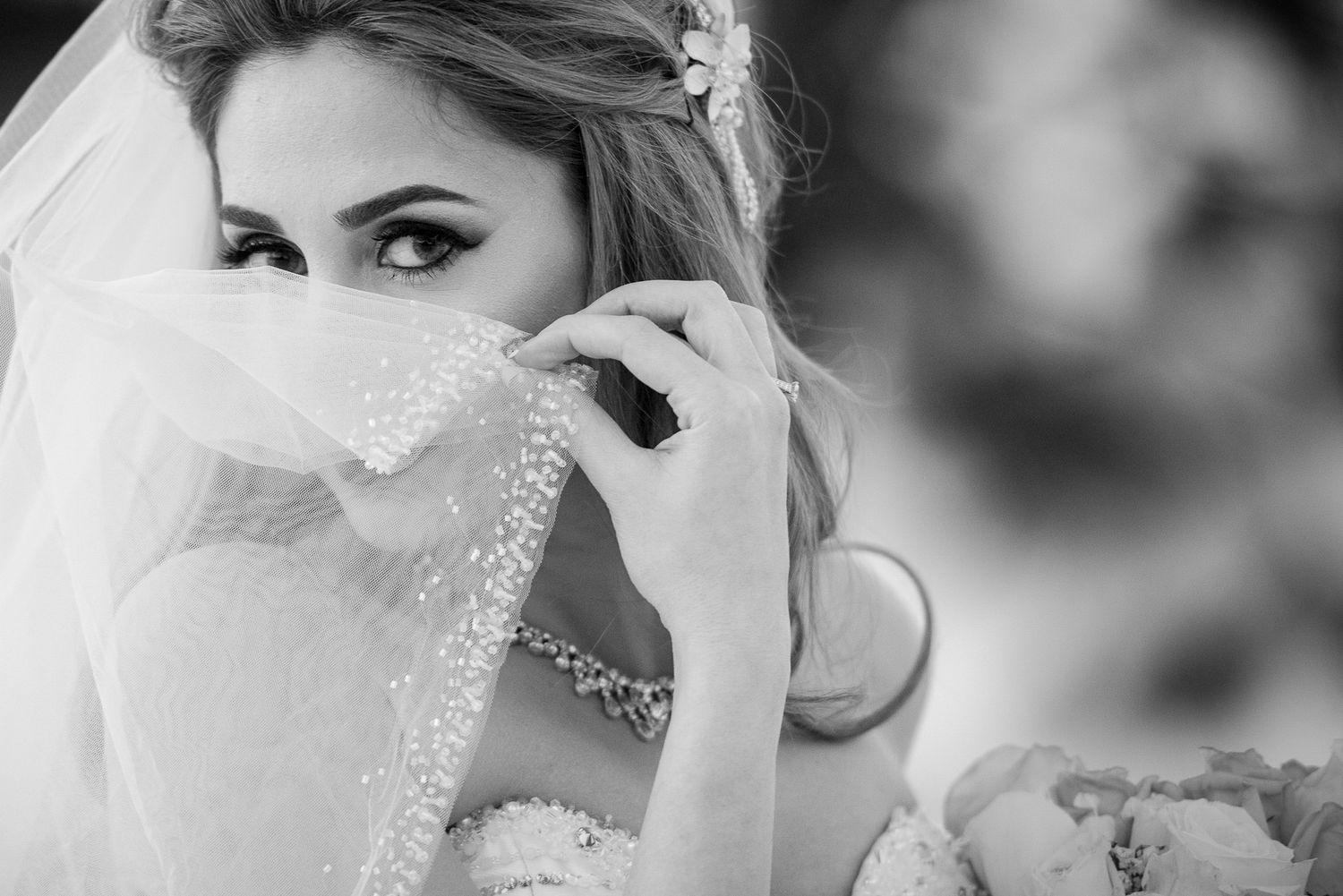 Artistic black and white portrait of bride with sparkly veil and jewelry.