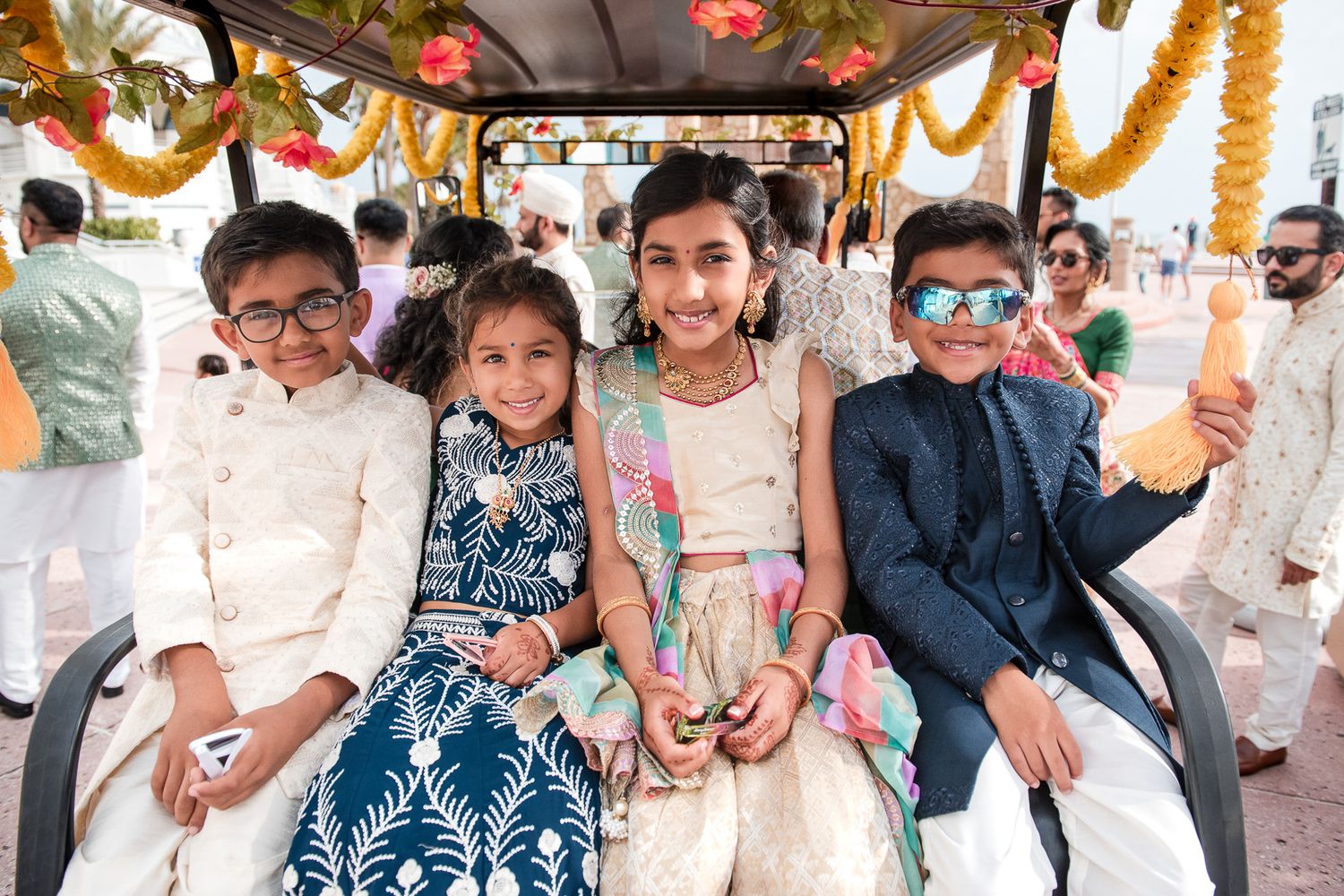 Guests seated at a decorated Indian wedding celebration wearing traditional attire.