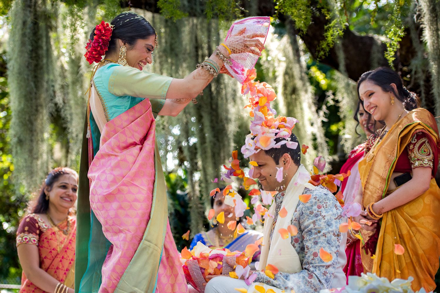 Colorful celebration with participants in traditional Indian attire performing wedding rituals.