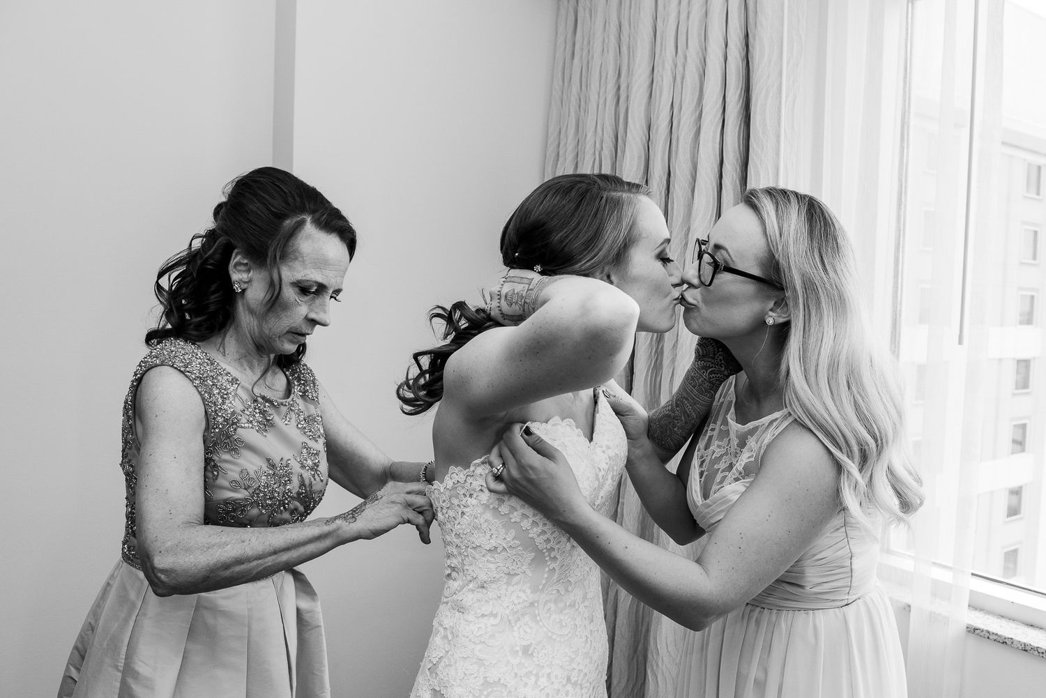 Black and white candid photo of wedding preparation moments.