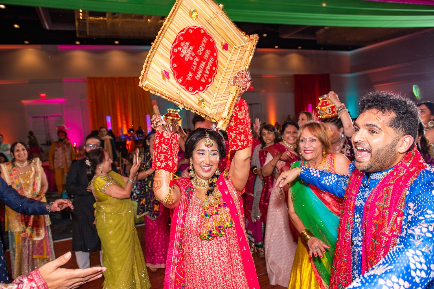 Festive Indian wedding celebration with guests dancing and celebrating in colorful traditional attire.