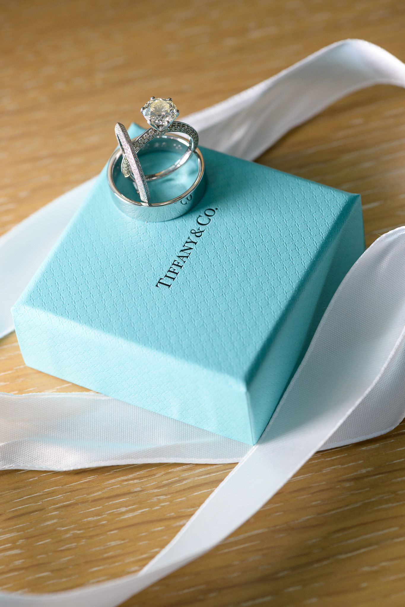 Wedding rings rest on a signature Tiffany & Co blue box with white ribbon.