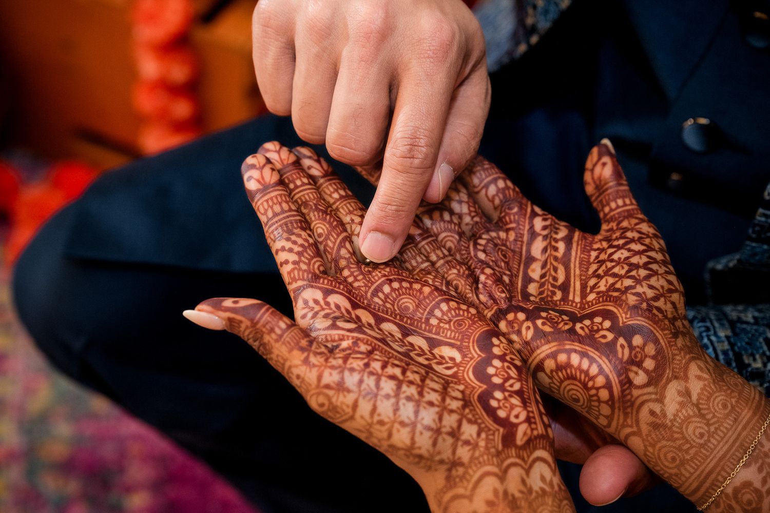 Detailed view of intricate mehndi design being examined on palm.