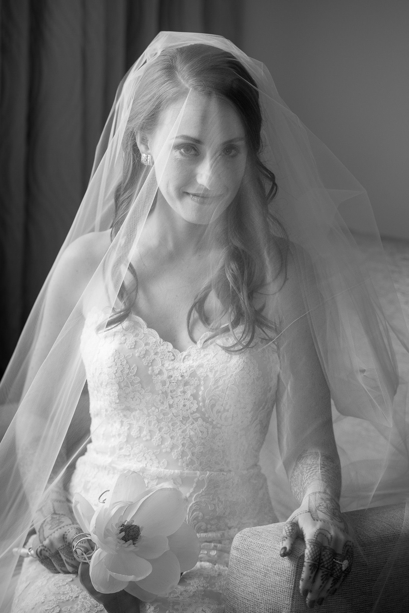 Classic black and white bridal portrait with lace dress and flowing veil.