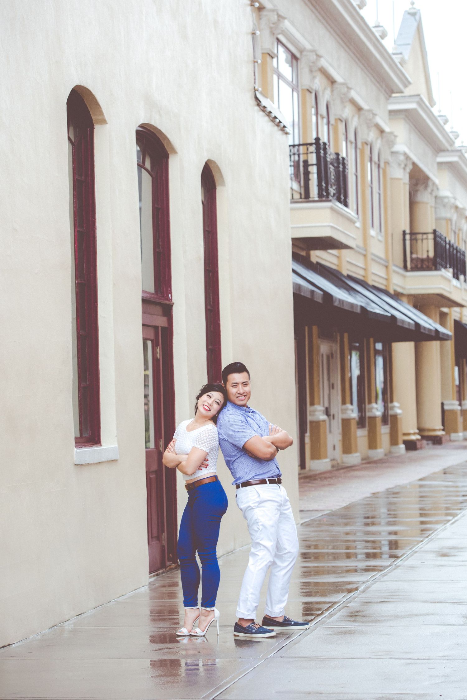 Romantic couple standing close together against a historic building facade.