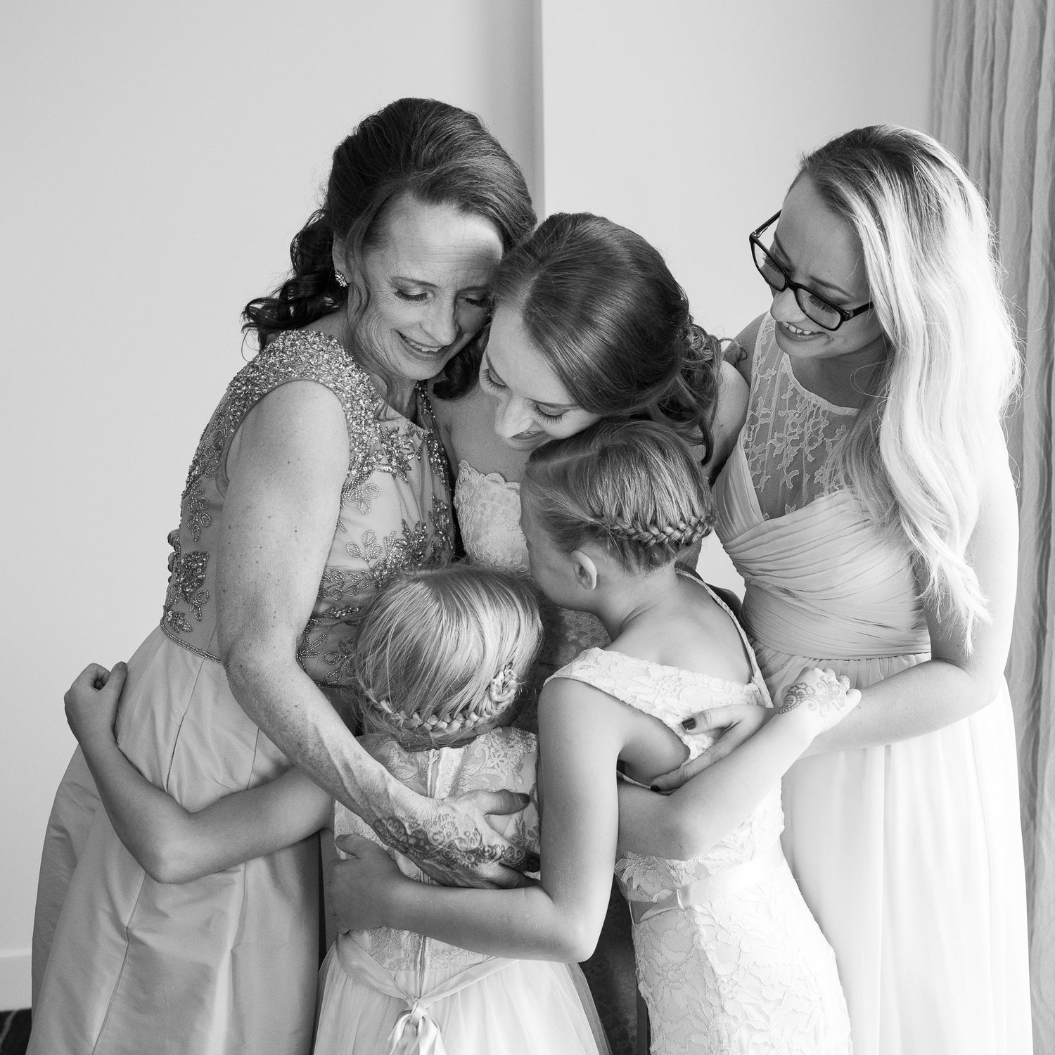 Intimate gathering sharing emotional embrace in formal attire.