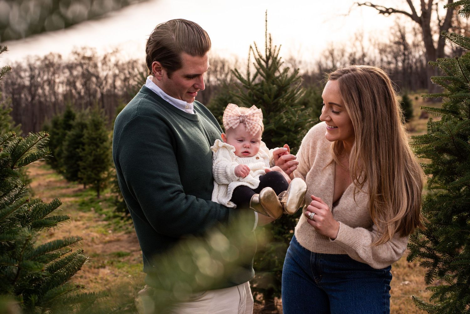 An intimate family photo session with warm tones among evergreen trees.