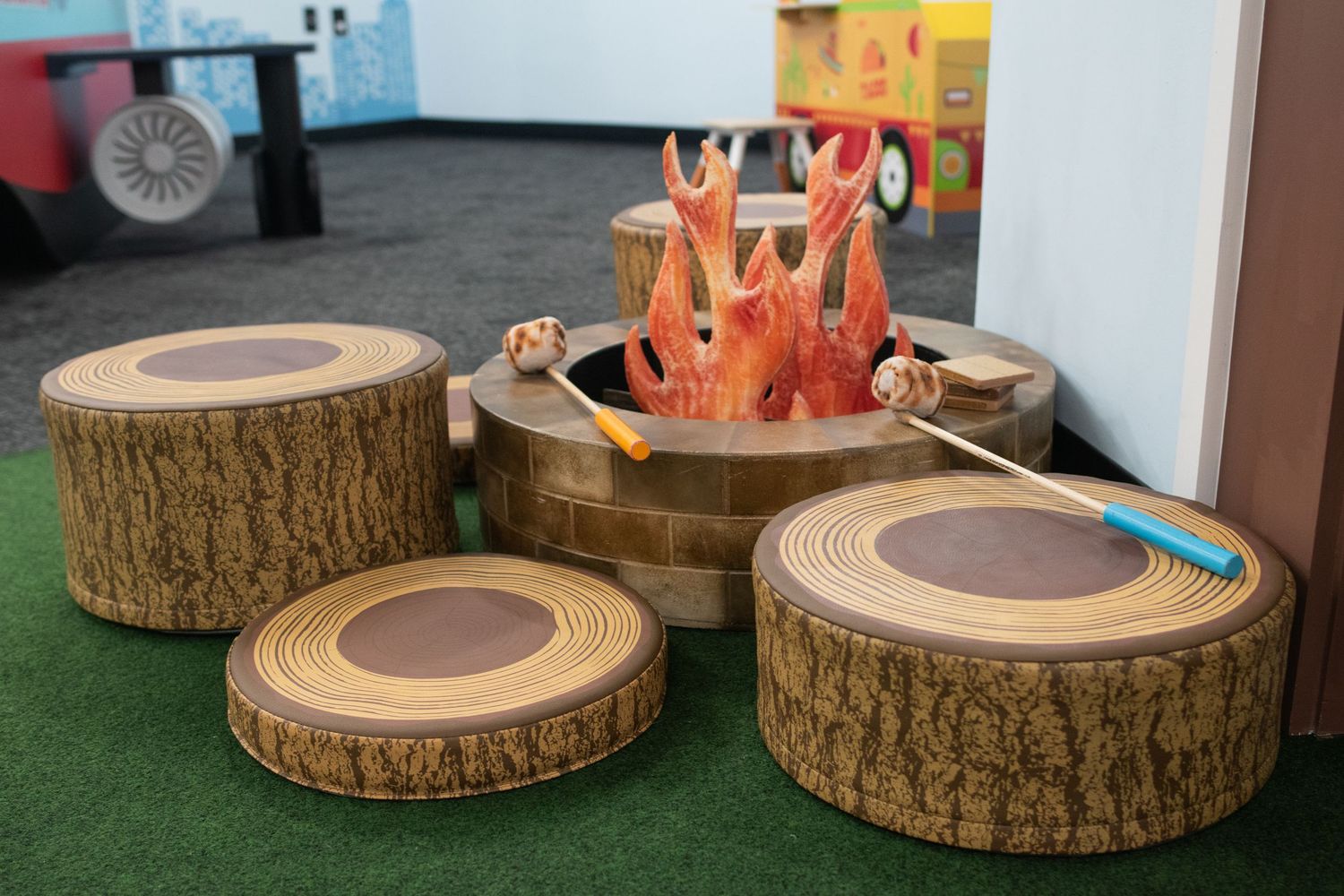 Decorative wooden tree stump platforms arranged in a circular pattern on artificial grass.