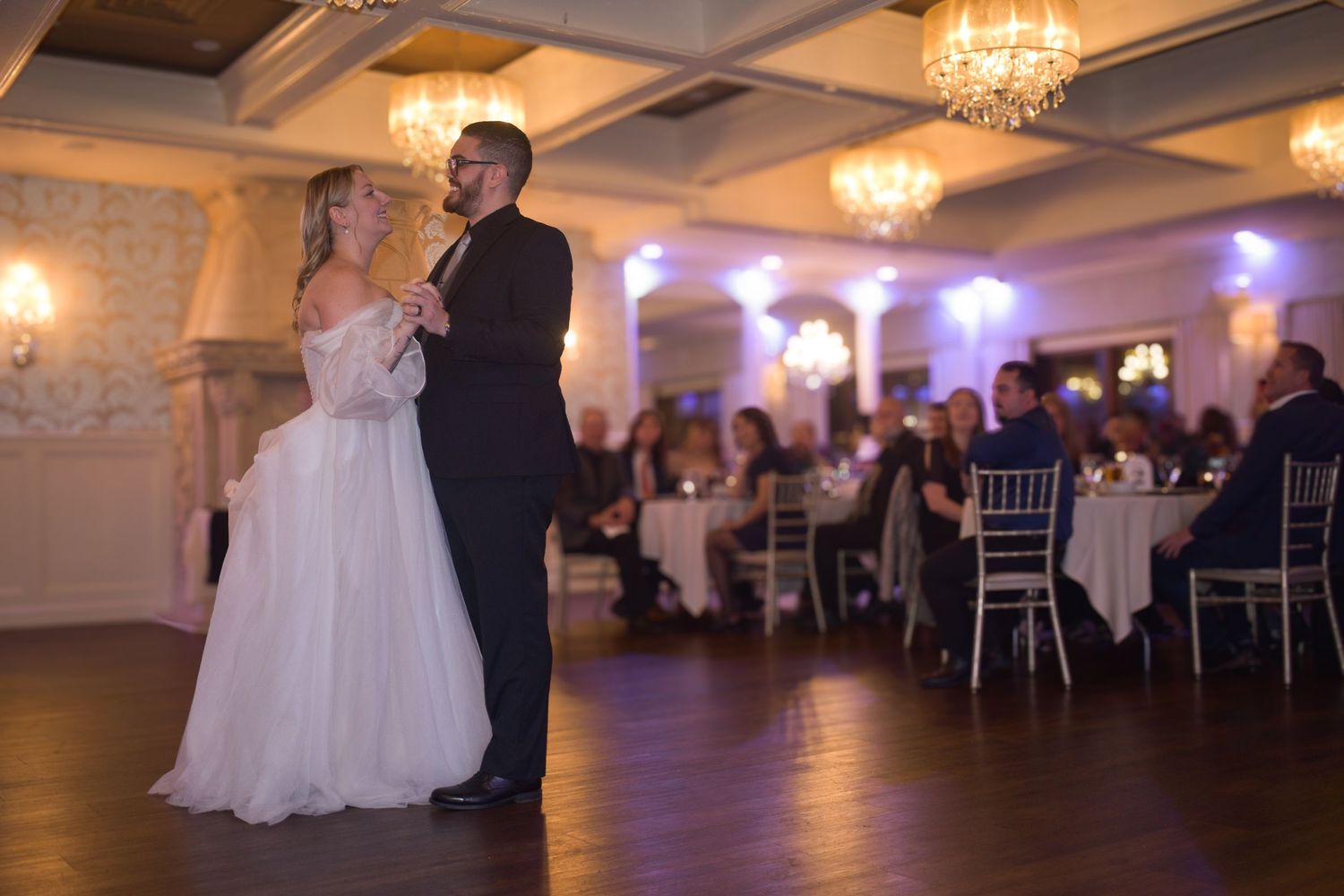 Elegant ballroom dance moment captured under crystal chandeliers.