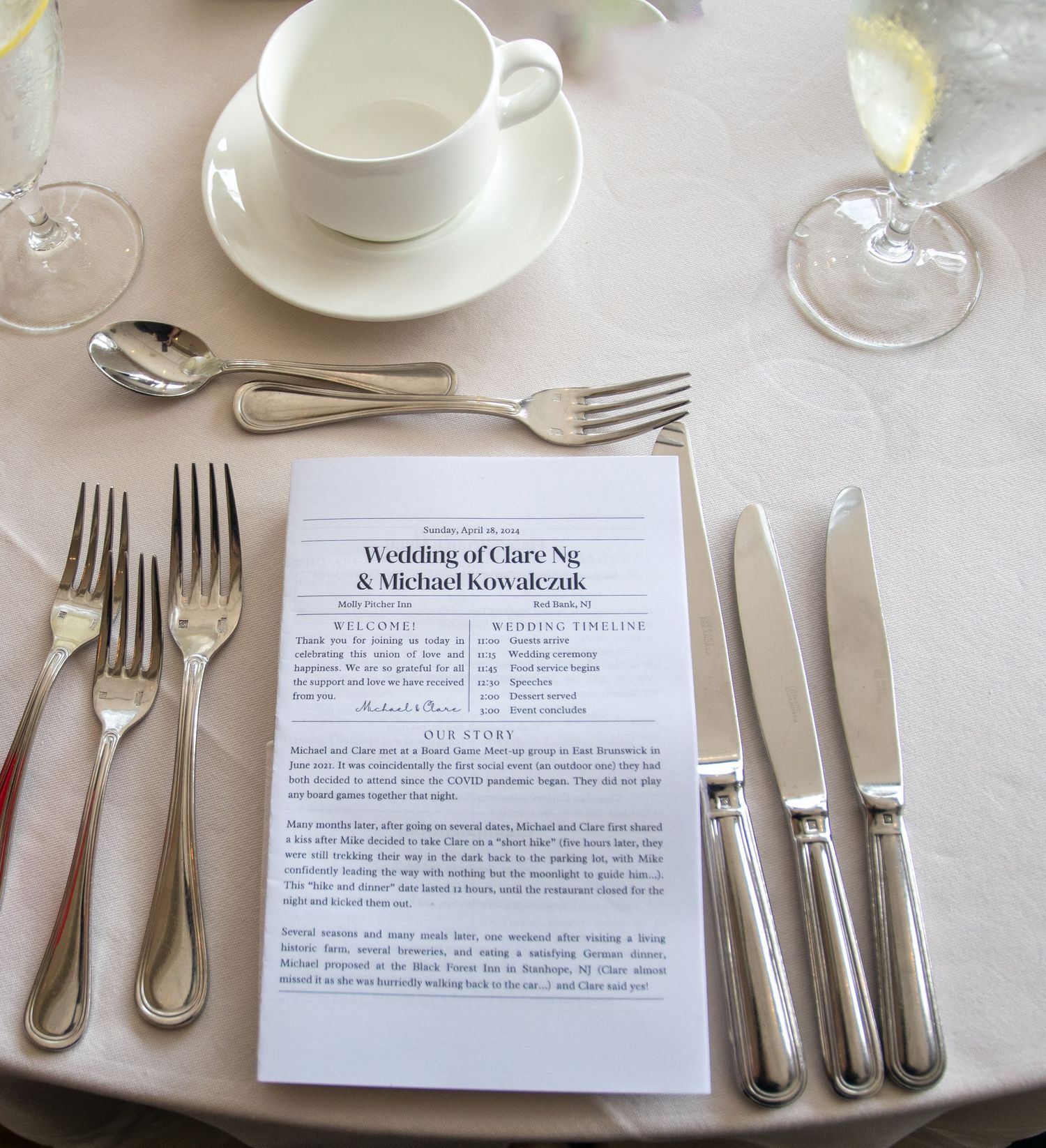 Elegant place setting with silverware and wedding ceremony program card.