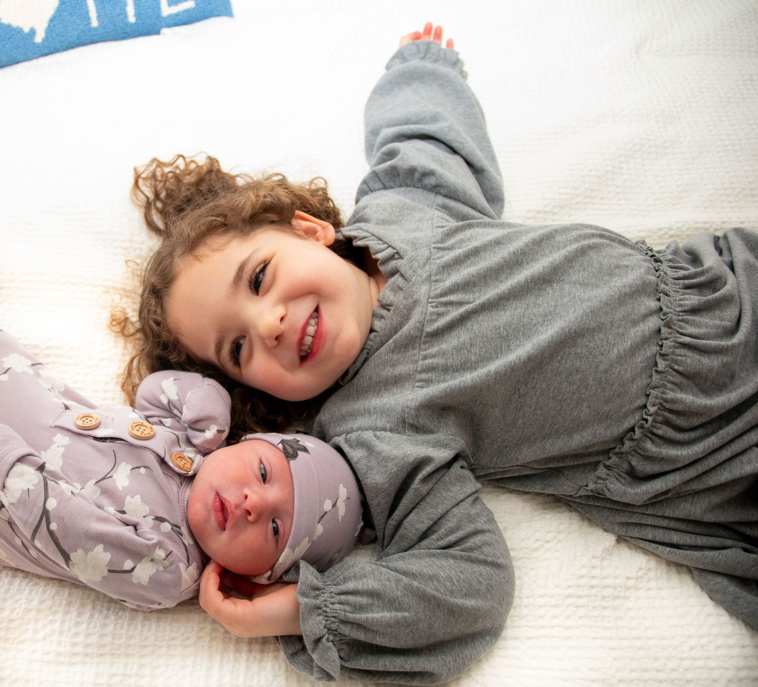 Candid playful moments captured on white bedding showing joyful expressions.