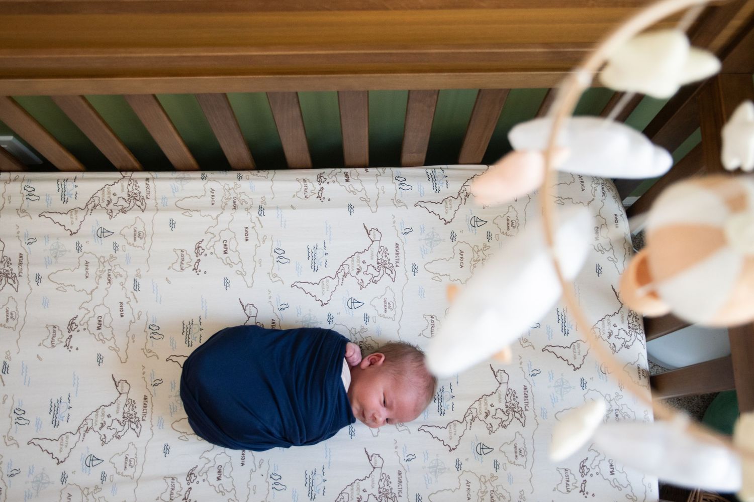 Looking down through wooden crib bars at peaceful nursery scene.