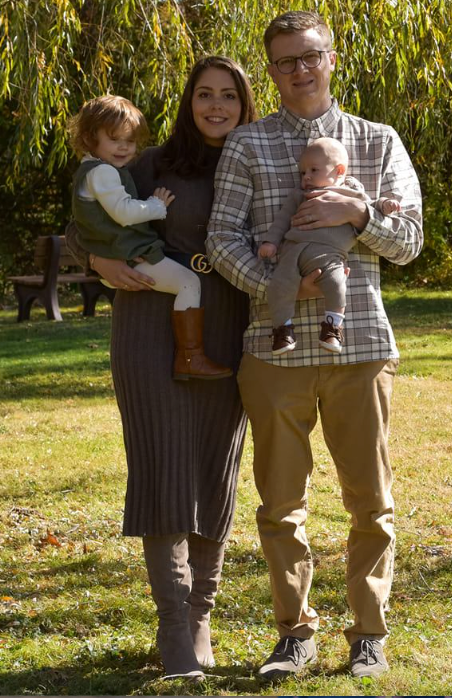 A family autumn portrait session with warm earth-toned outfits against willow trees.