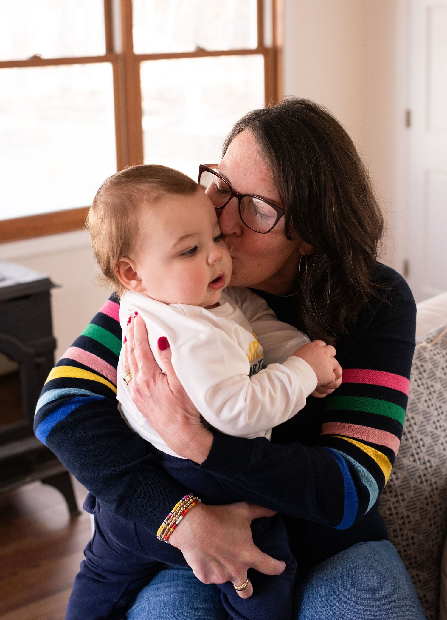 Tender moment shared between parent and child on a cozy couch indoors.