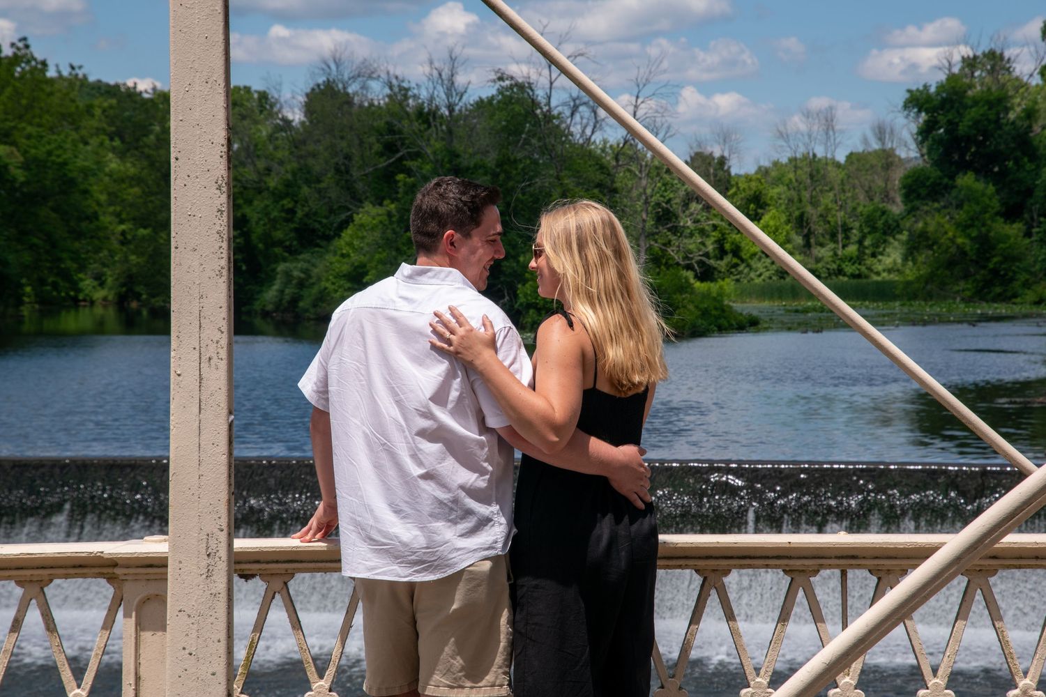A couple shares an intimate moment on a lakeside deck.
