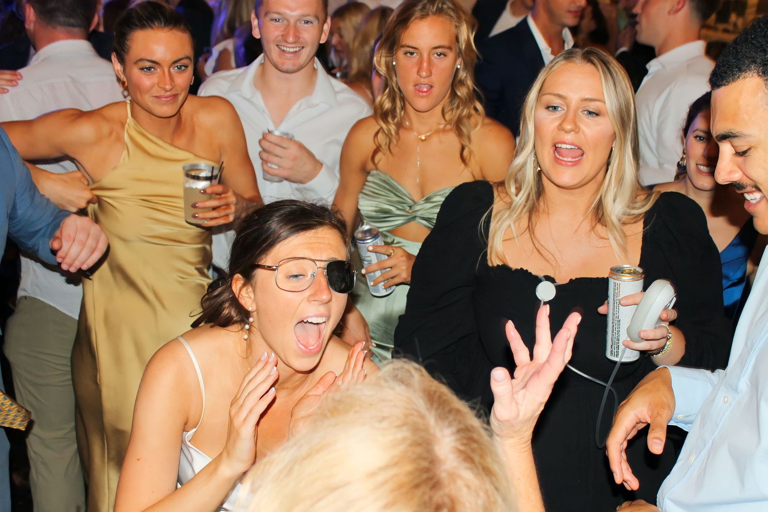 Wedding guests dance and celebrate at a lively reception party.
