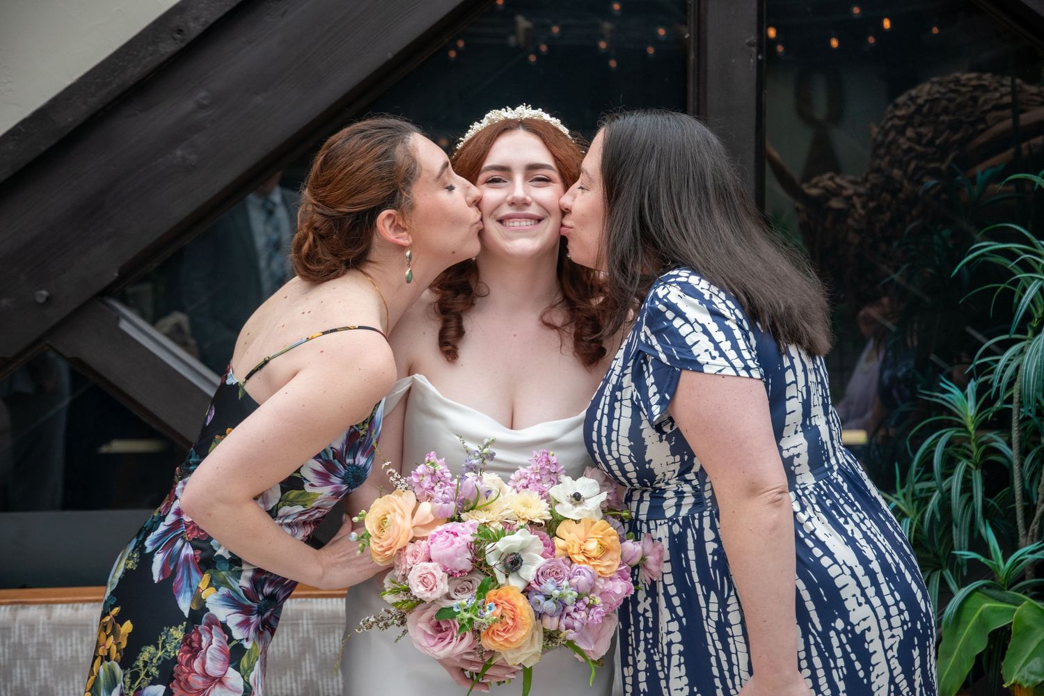 Wedding party celebrating with group hugs and floral bouquets.
