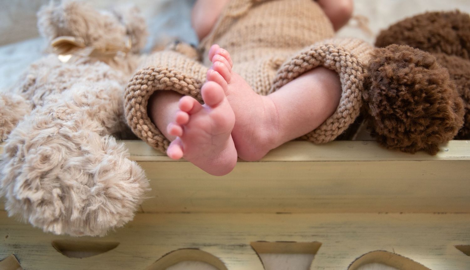 Series of newborn photos showing baby lying on white blanket.