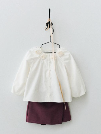 Four product photos showing a white and burgundy two-tone children's dress on hangers against a light background.