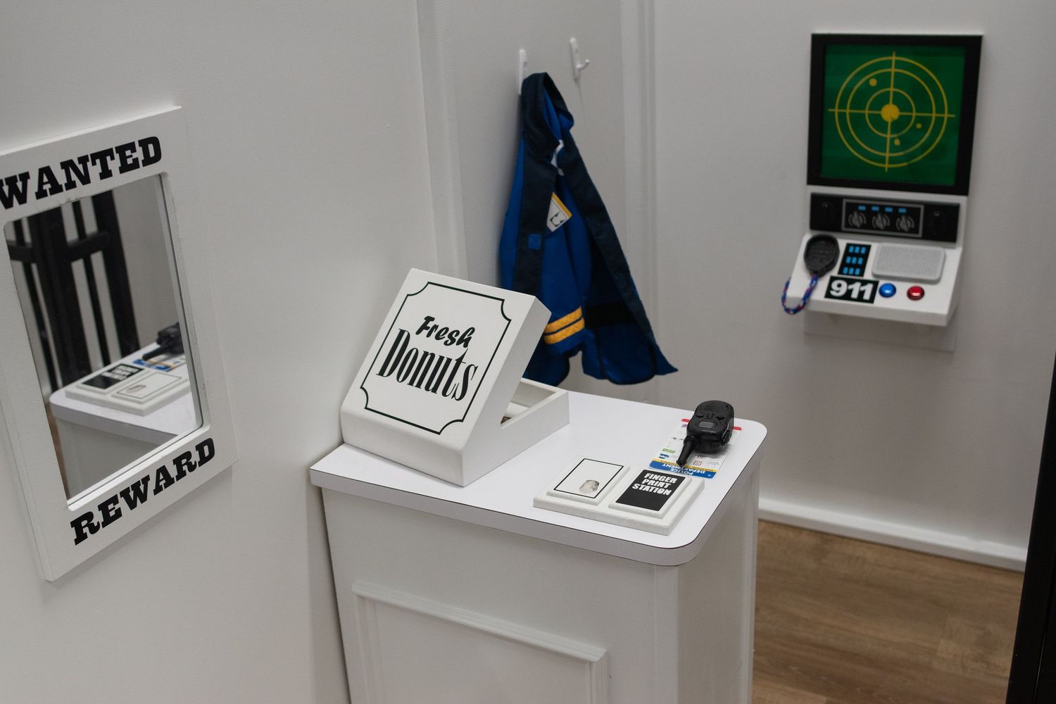 White shelving display with wanted posters and target graphics in a playroom setting.