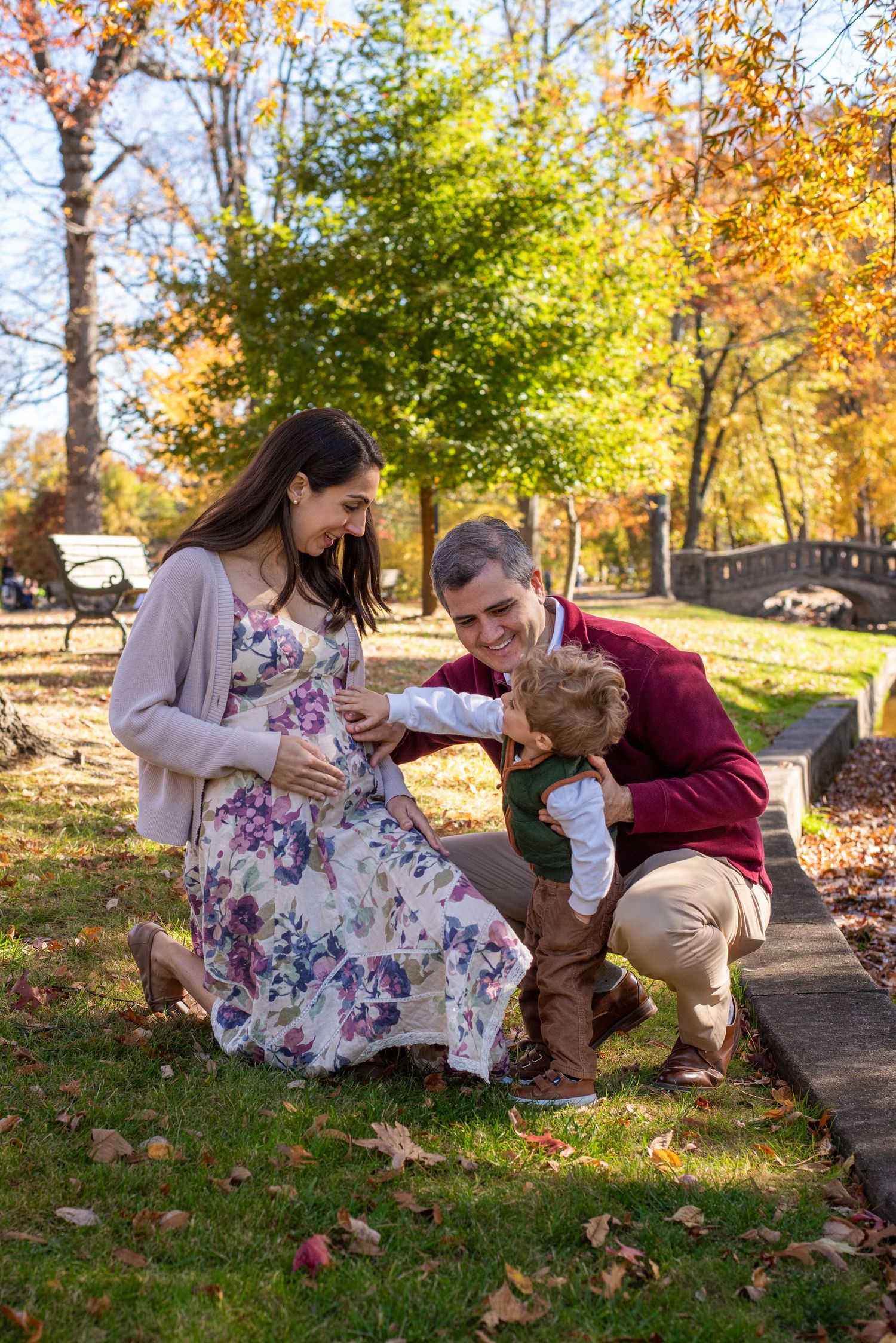Family having a picnic outdoors on a beautiful autumn day with colorful fall foliage in the background.