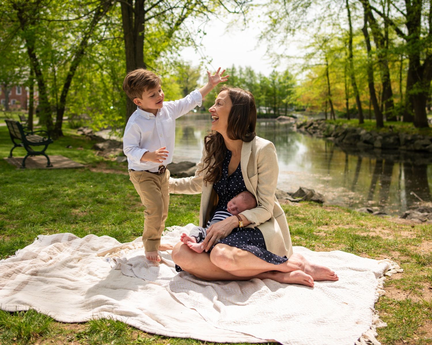 Family spending quality time together on white blanket in spring park setting.