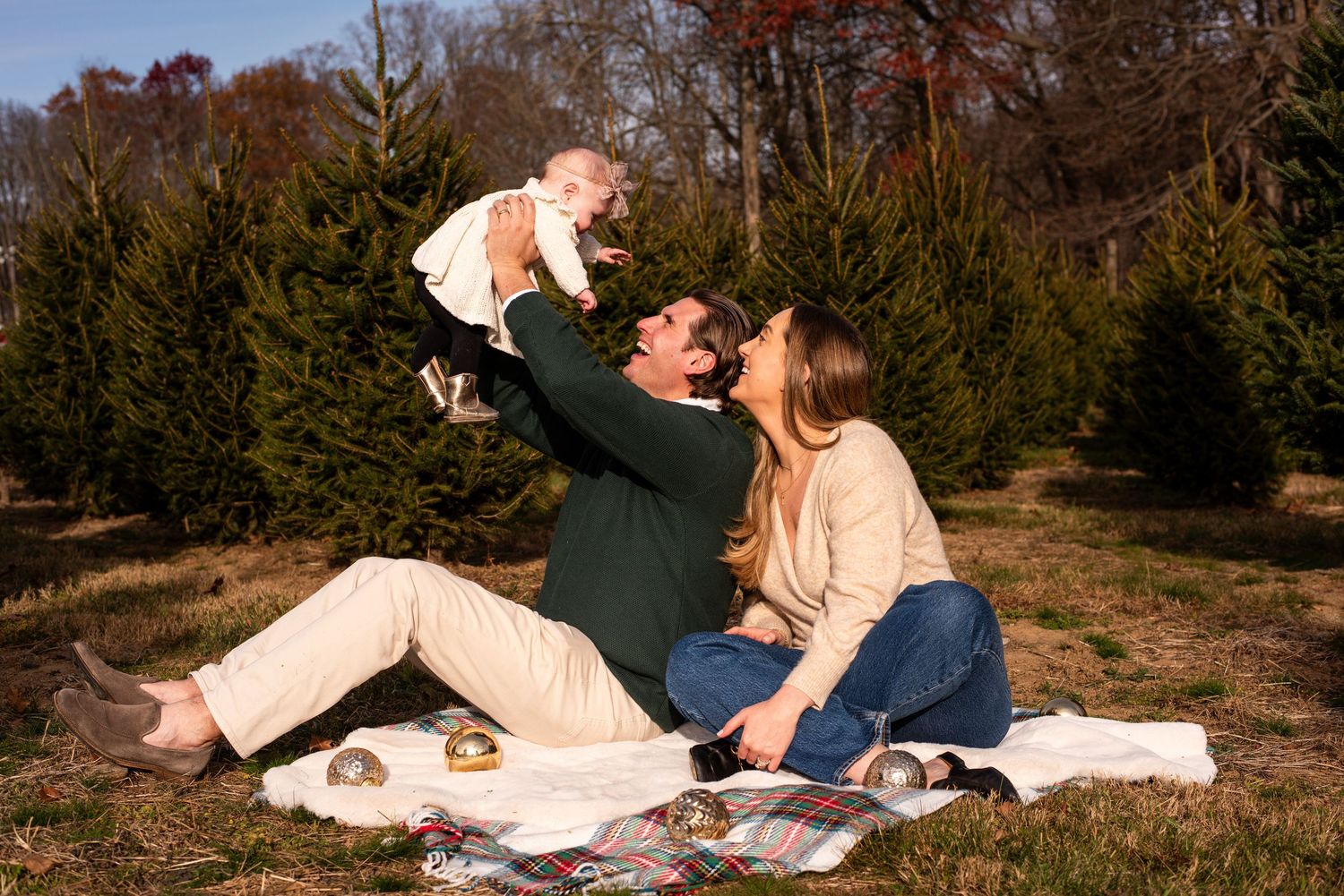 A romantic picnic scene at sunset with cozy blankets on an autumn hillside.