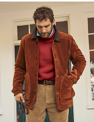 Person in a burgundy sweater and brown corduroy jacket poses in three similar stances against a white wall.