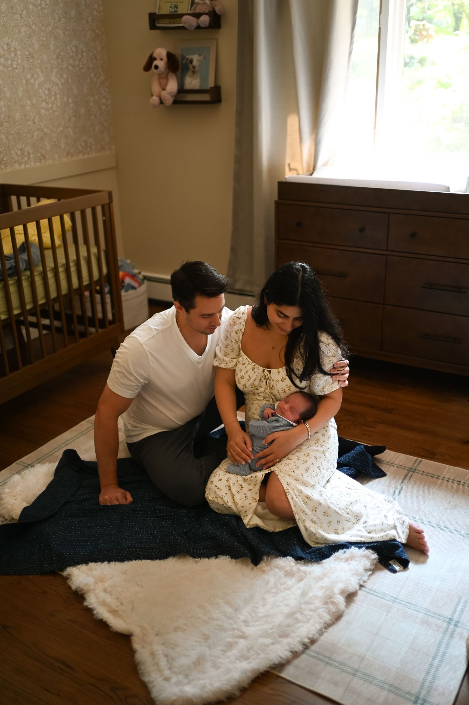 A couple shares an intimate moment while lying on a plush white rug indoors.