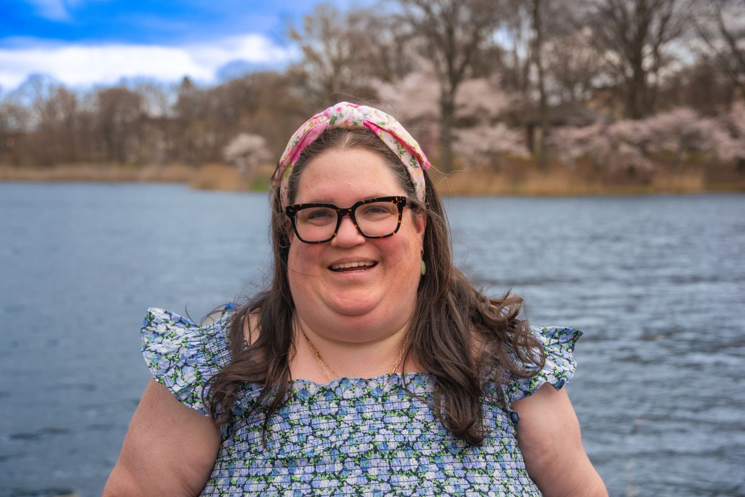 A lakeside portrait series with trees and water in the background on a cloudy day.