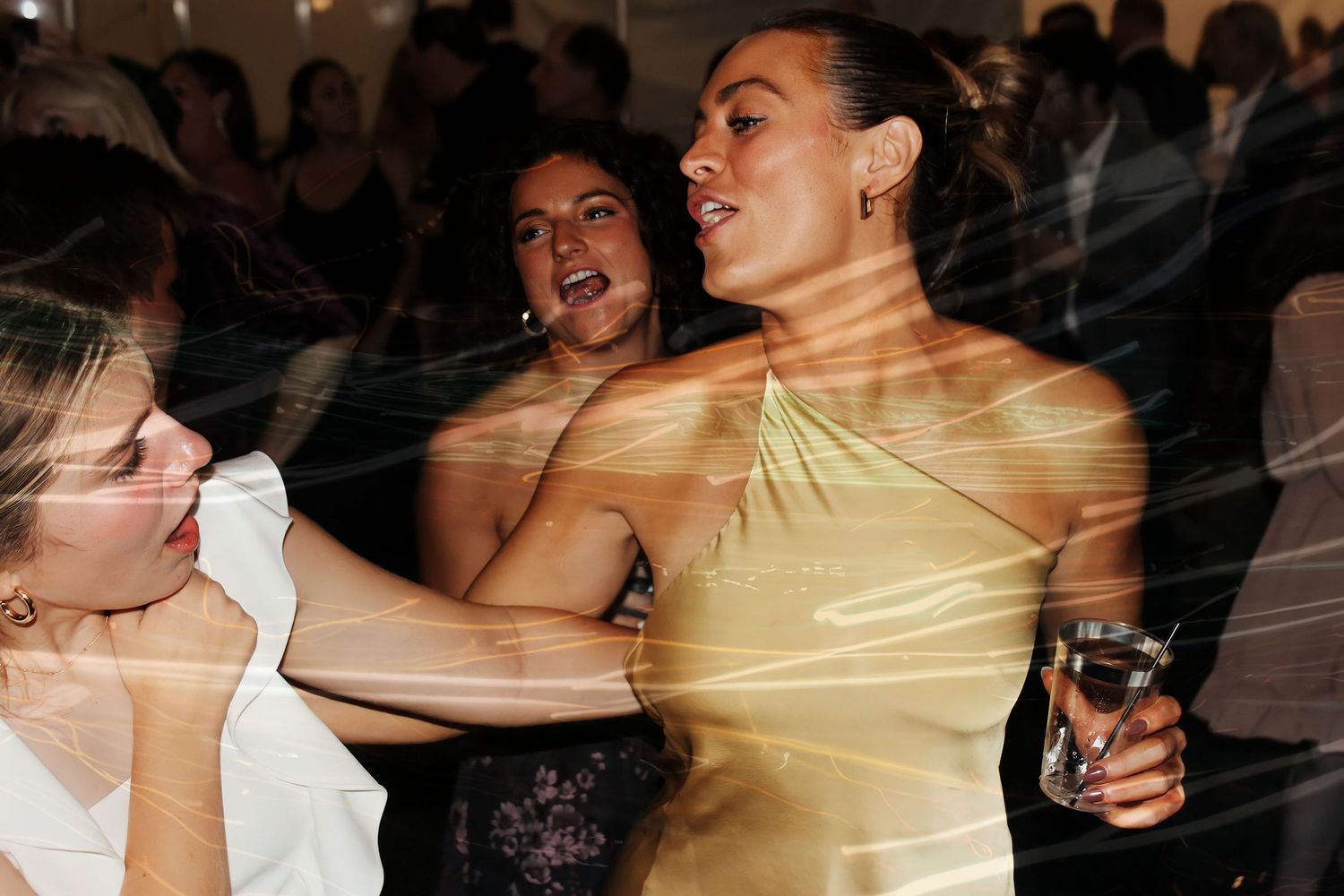 Dark silhouettes of people dancing at a wedding reception party.