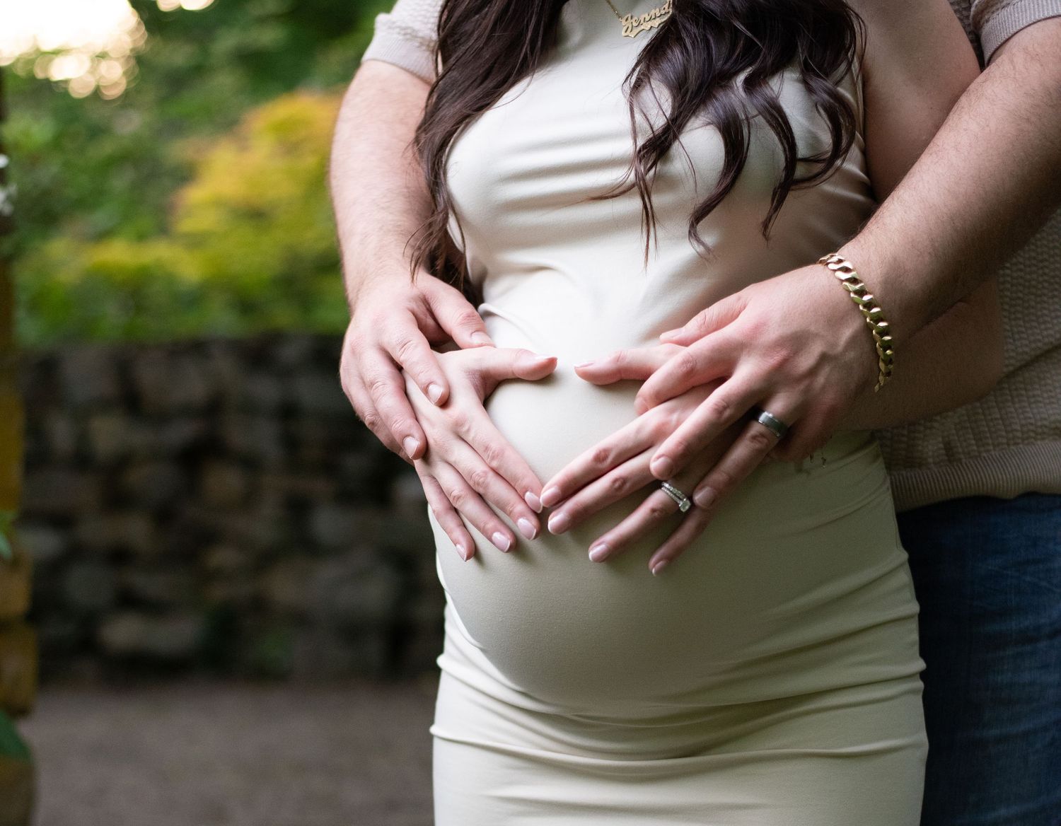 Close-up shots of pregnant belly in white dress against natural outdoor background.