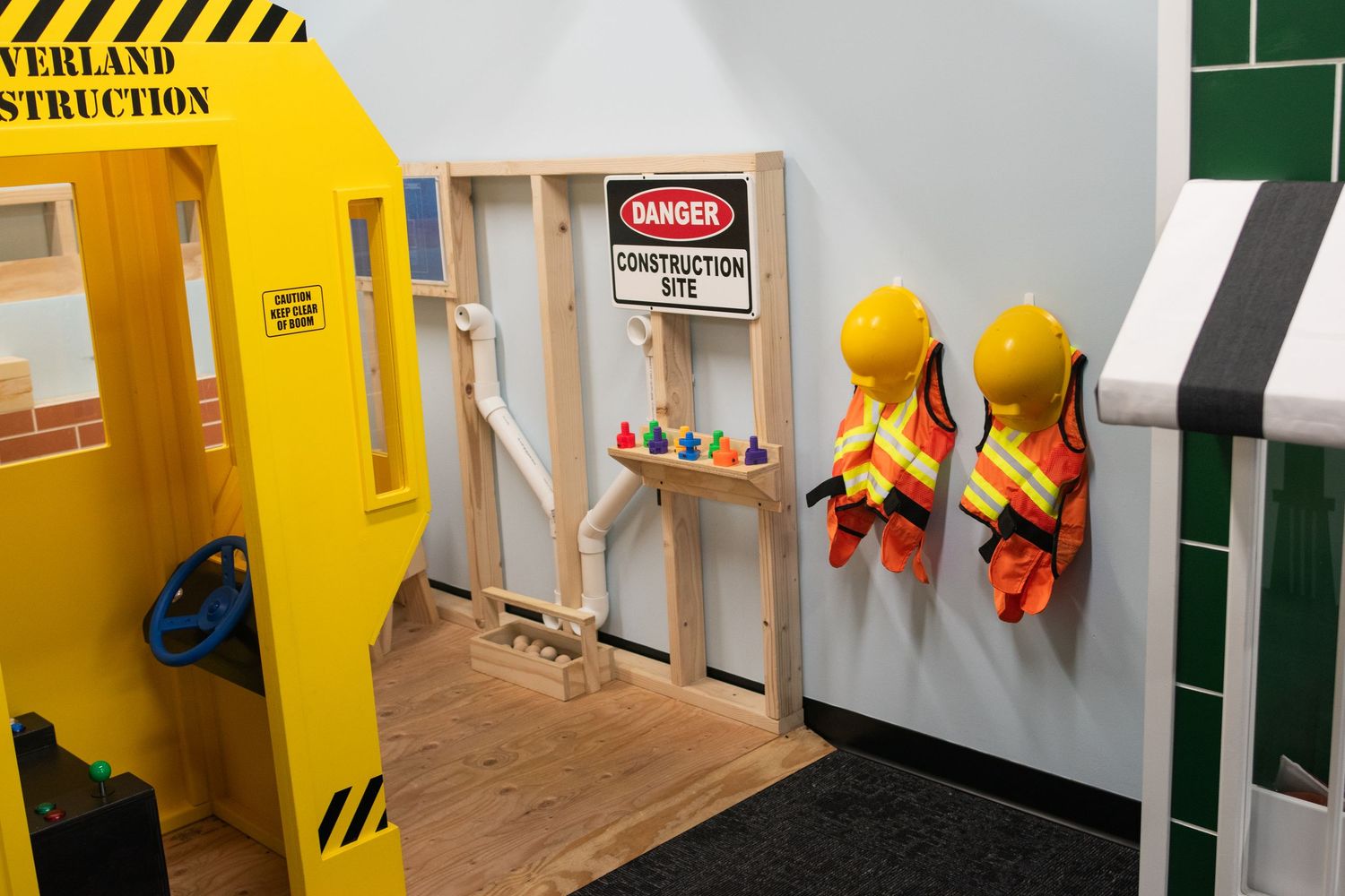 Yellow children's play area with construction-themed decor and safety signs.
