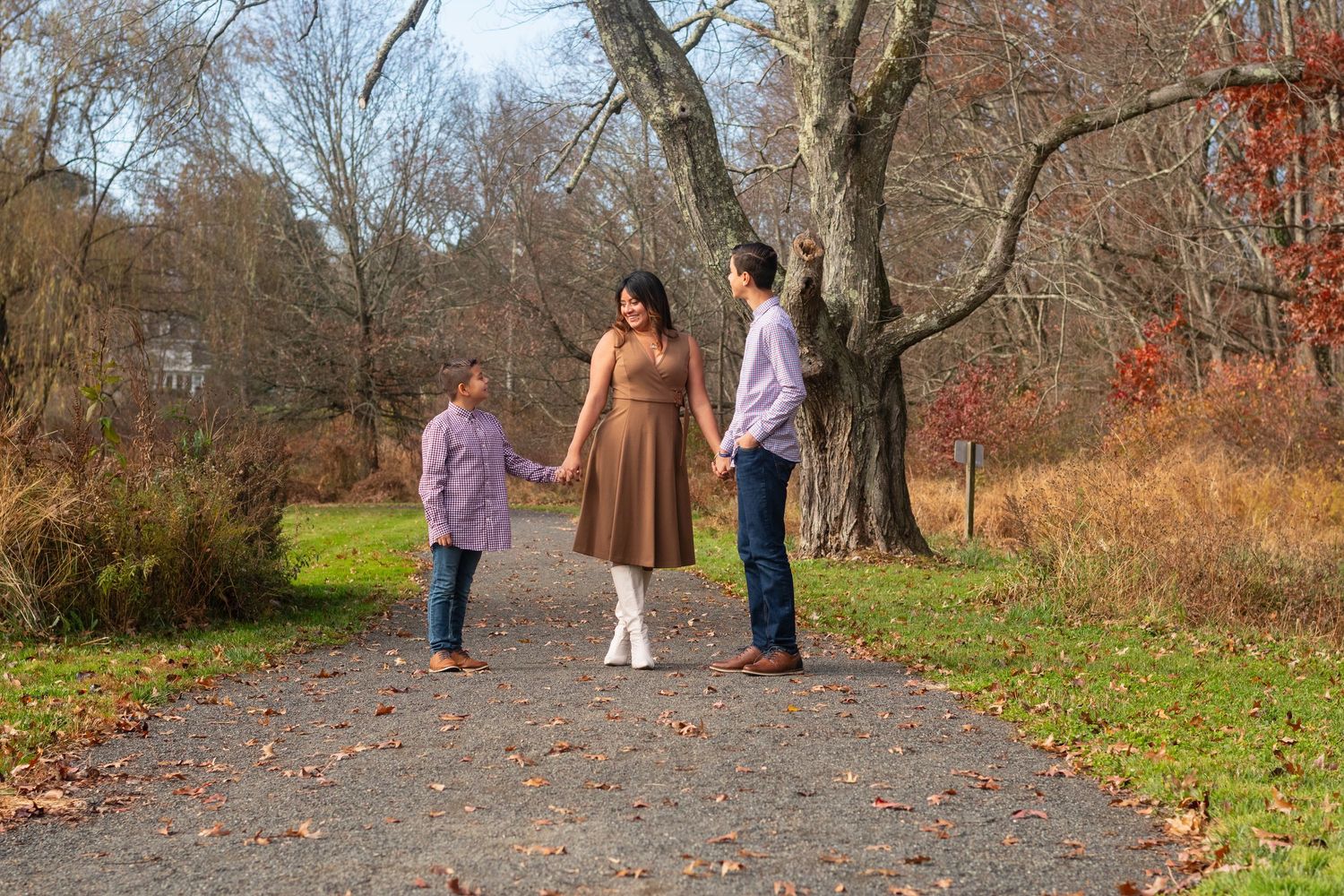 People walking along a tree-lined path during an autumn photo session.
