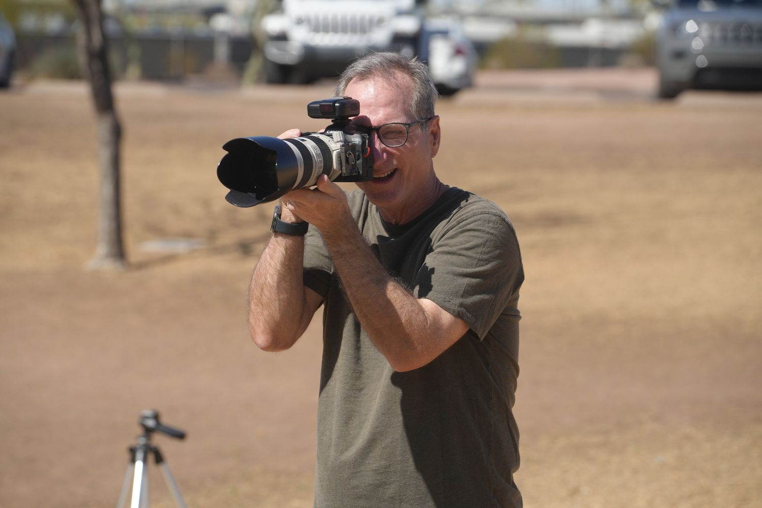 Tom is holding a camera and enjoying a photo shoot