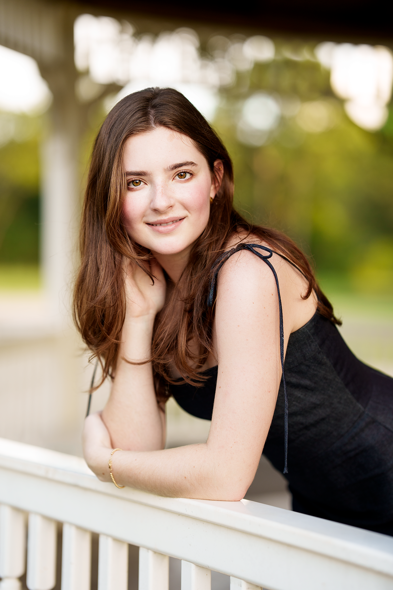 senior photos in the woodlands.  senior photographer image of a girl on a white fence.