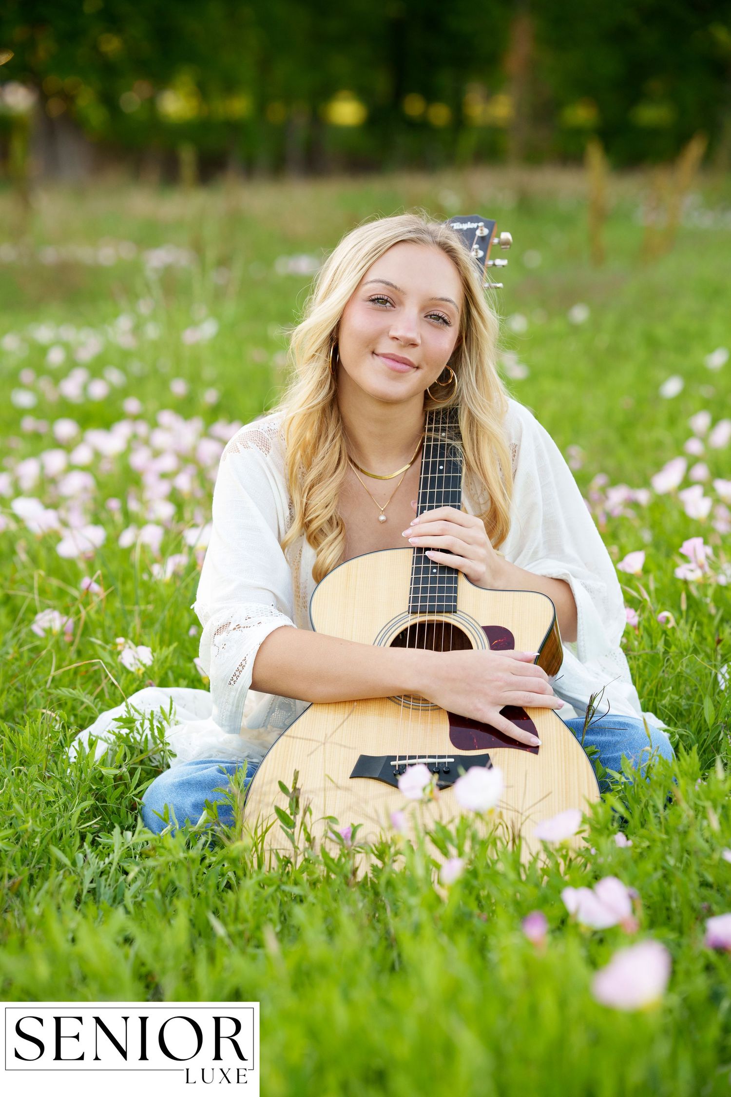 Senior photographer in the Woodlands .  Guitar senior girl photo session in a field with flowers.