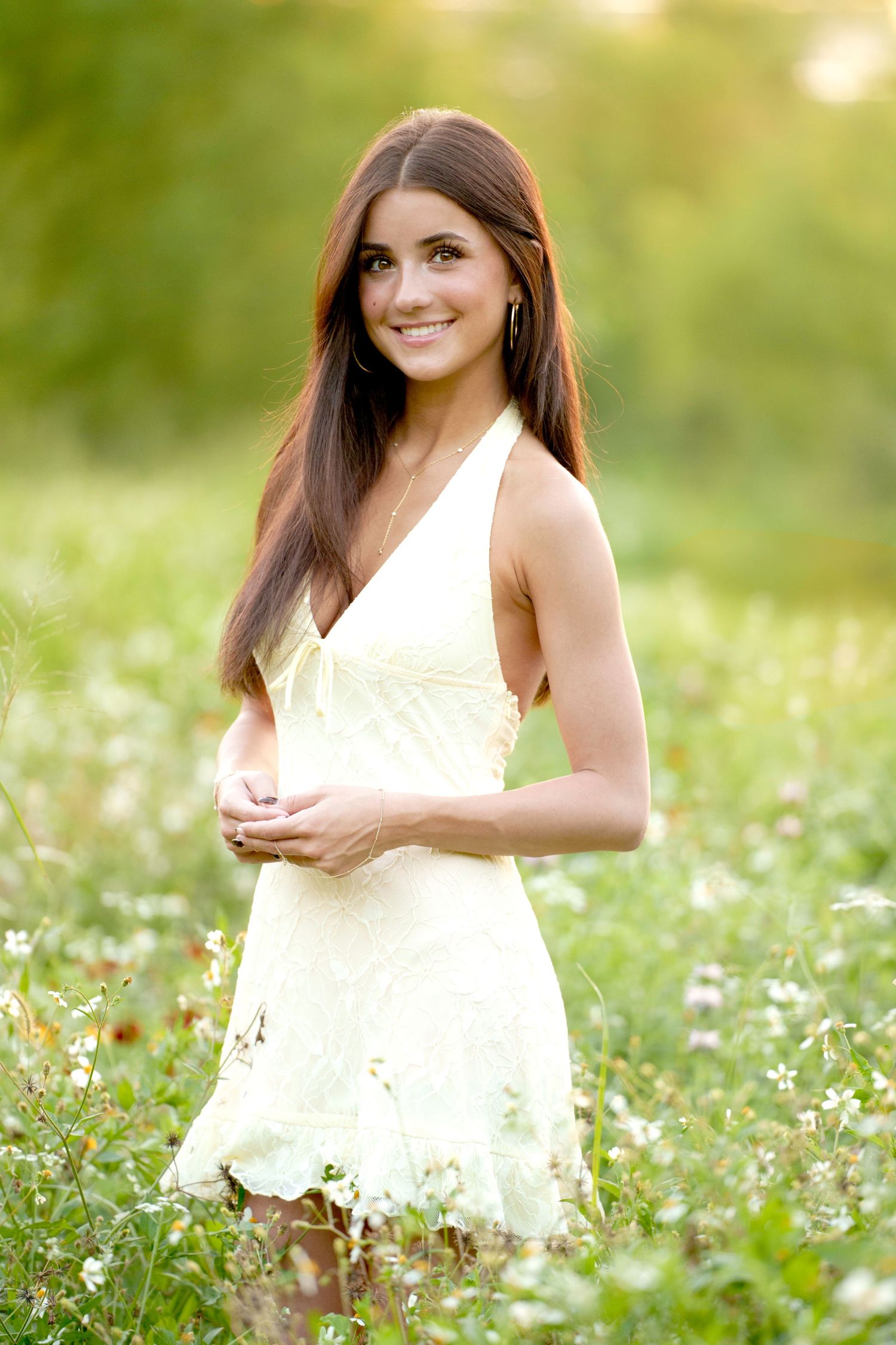 the woodlands senior photographer with a senior girl in a wildflower field at sunset