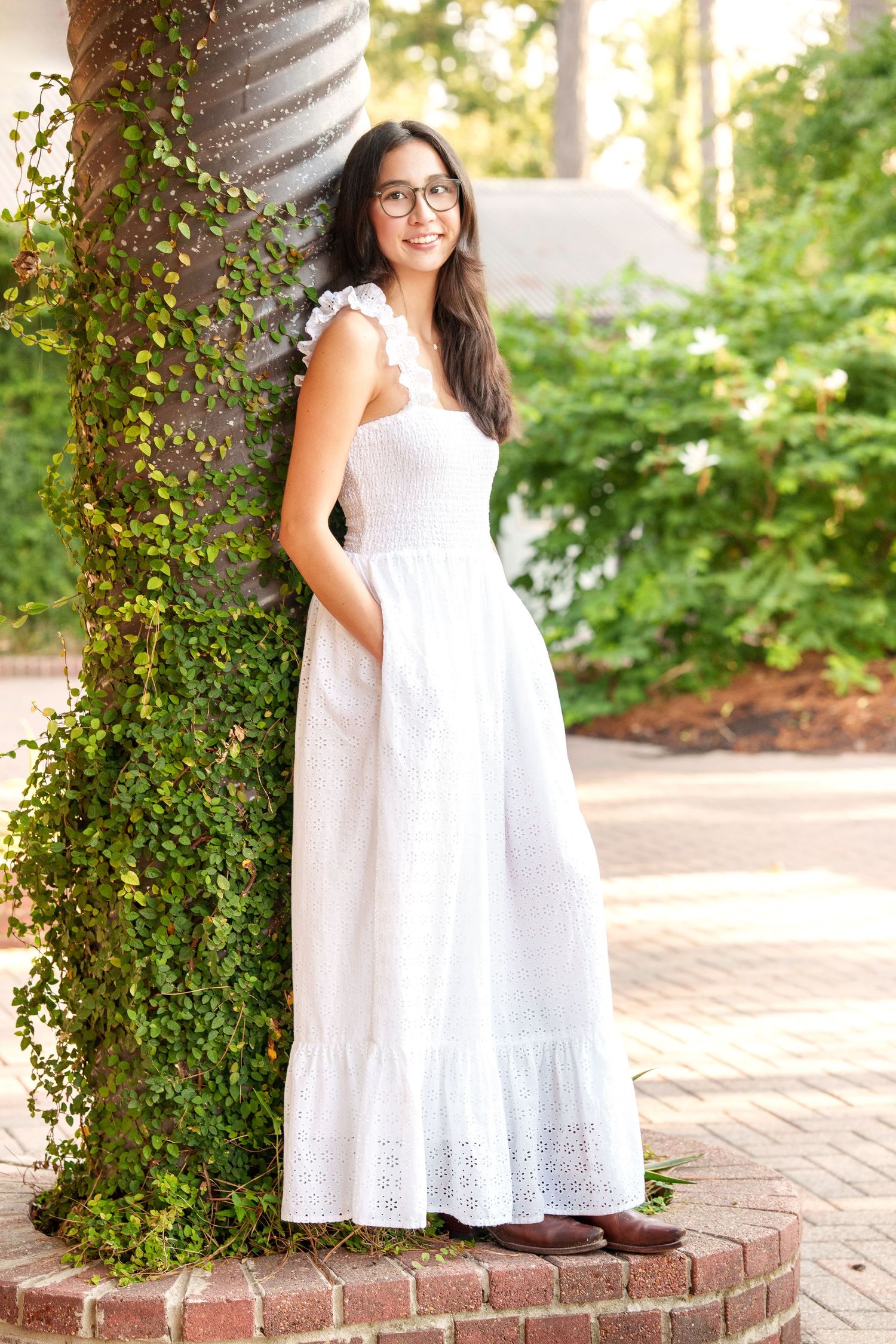 senior photos in the woodlands with a girl in a long white eyelet dress and ivy
