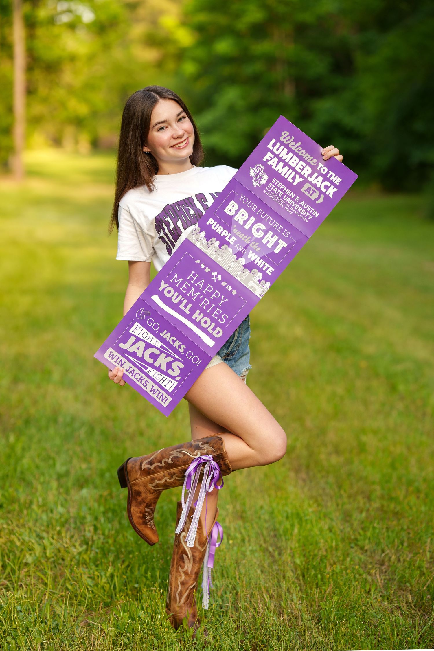 senior girl with acceptance banner in a field