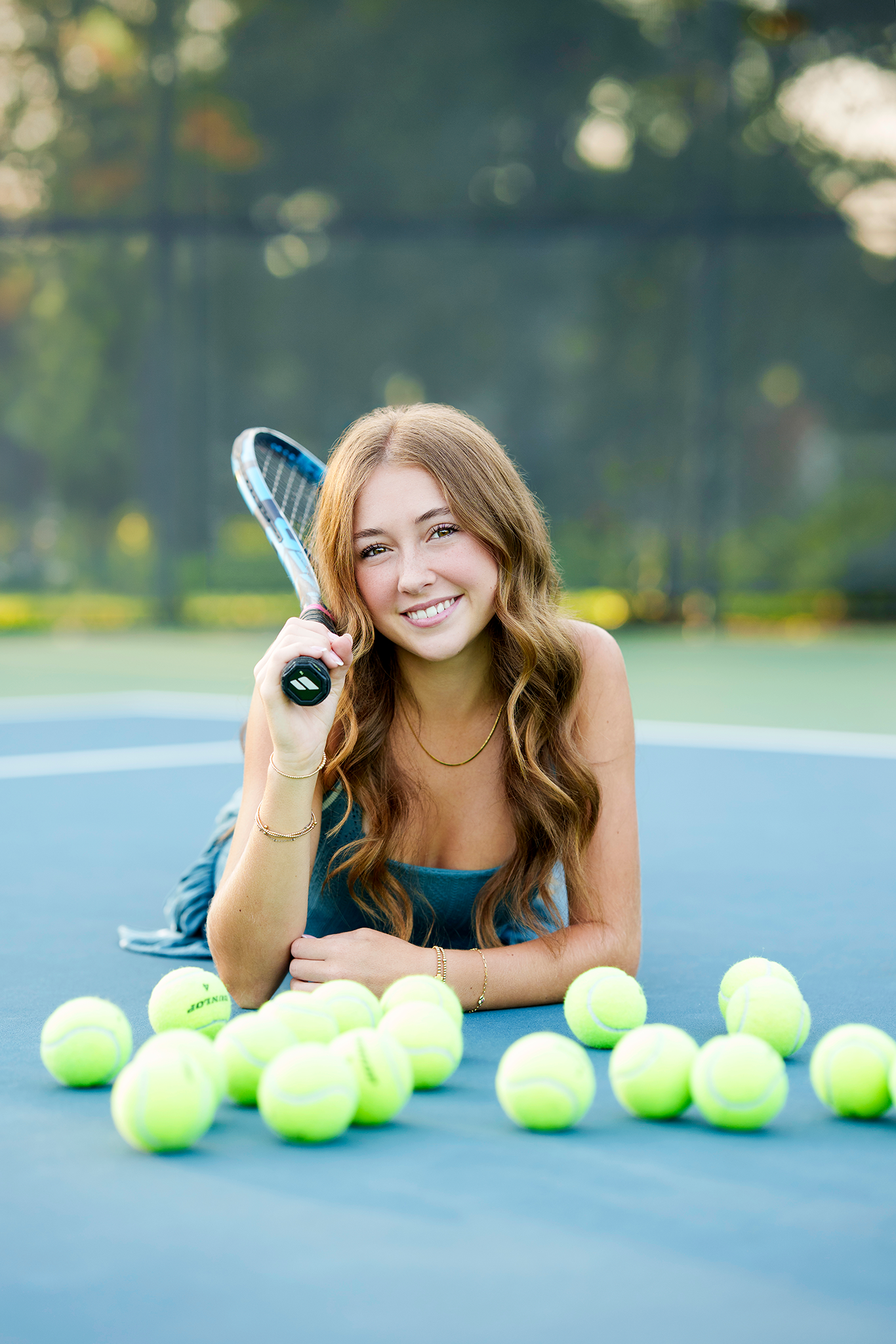 senior photographer in the woodlands with a female tennis player on a tennis court.  Tennis senior photos. Woodlands high school