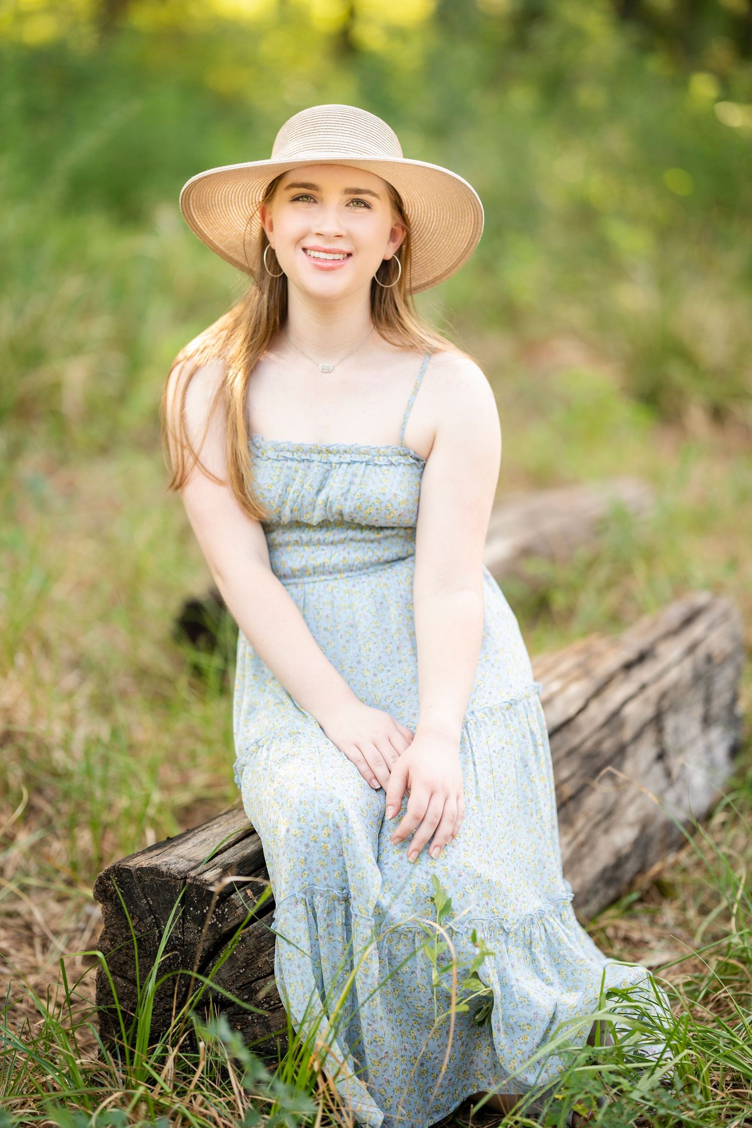 senior girl sitting on a log