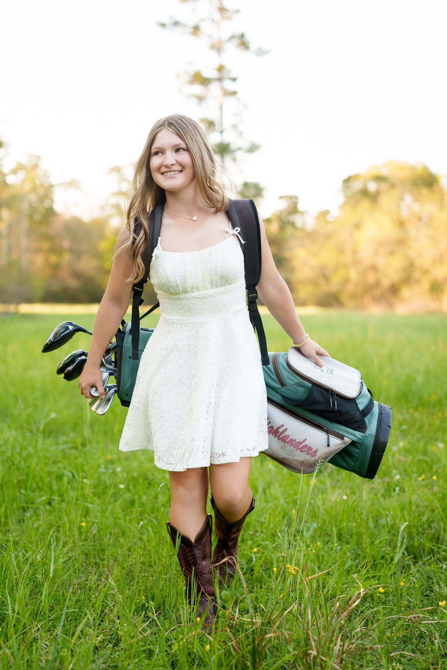 golf girl walking with her bag for her senior photos.  the woodlands golfer