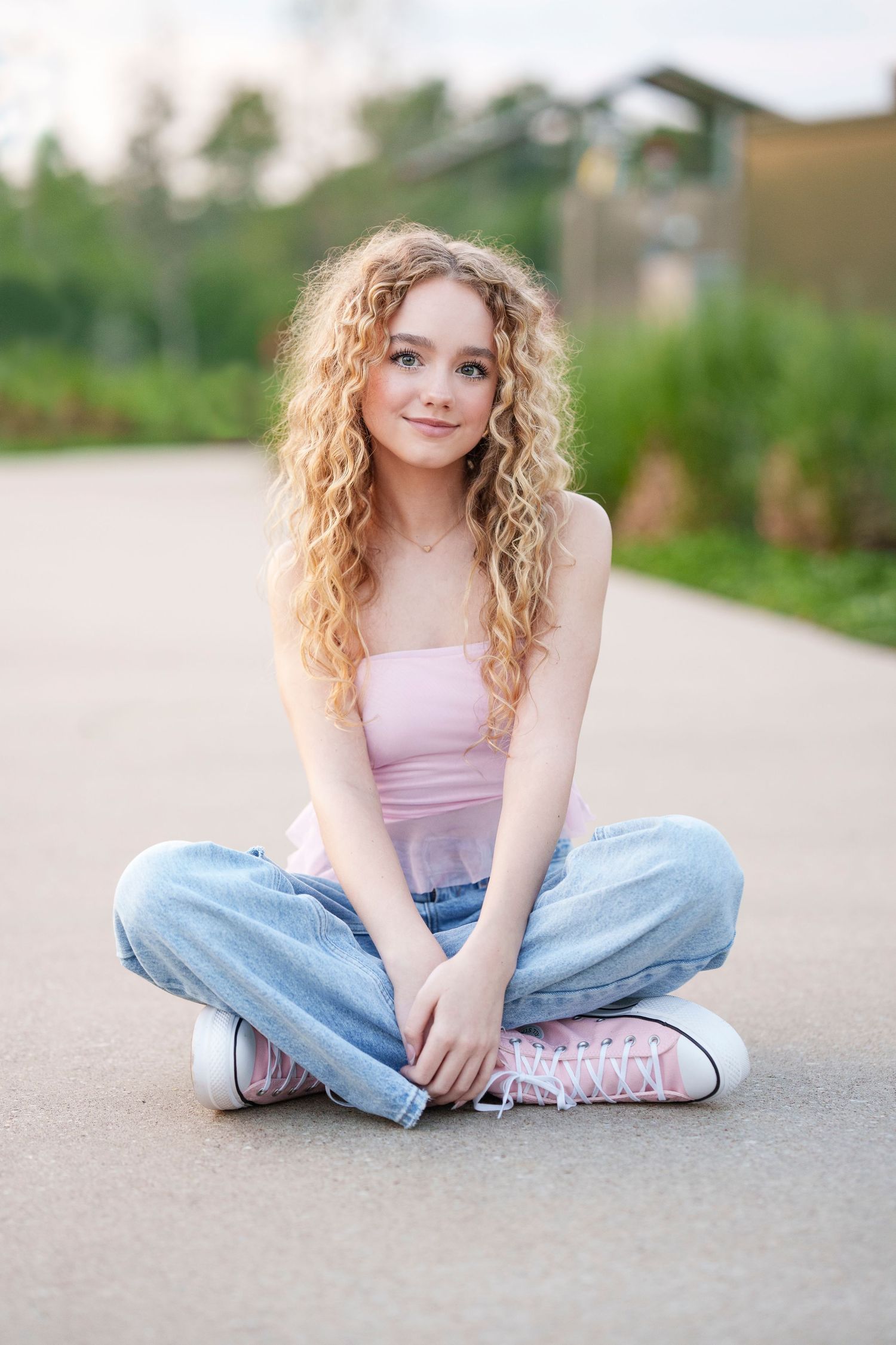 senior girl sitting on the sidewalk