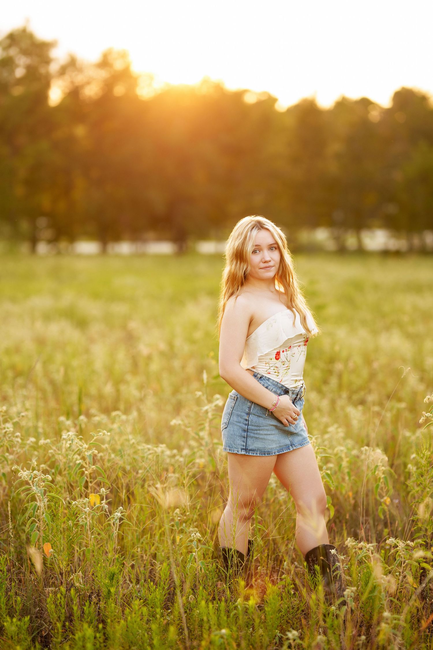 senior girl at golden hour in a field in the woodlands