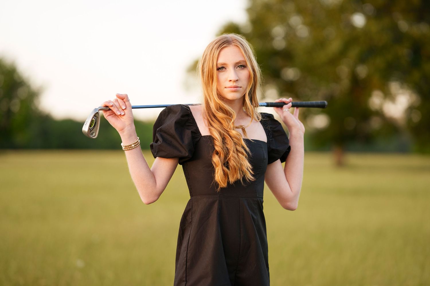 senior golf photo in the woodlands.  senior girl with golf club over her shoulder.