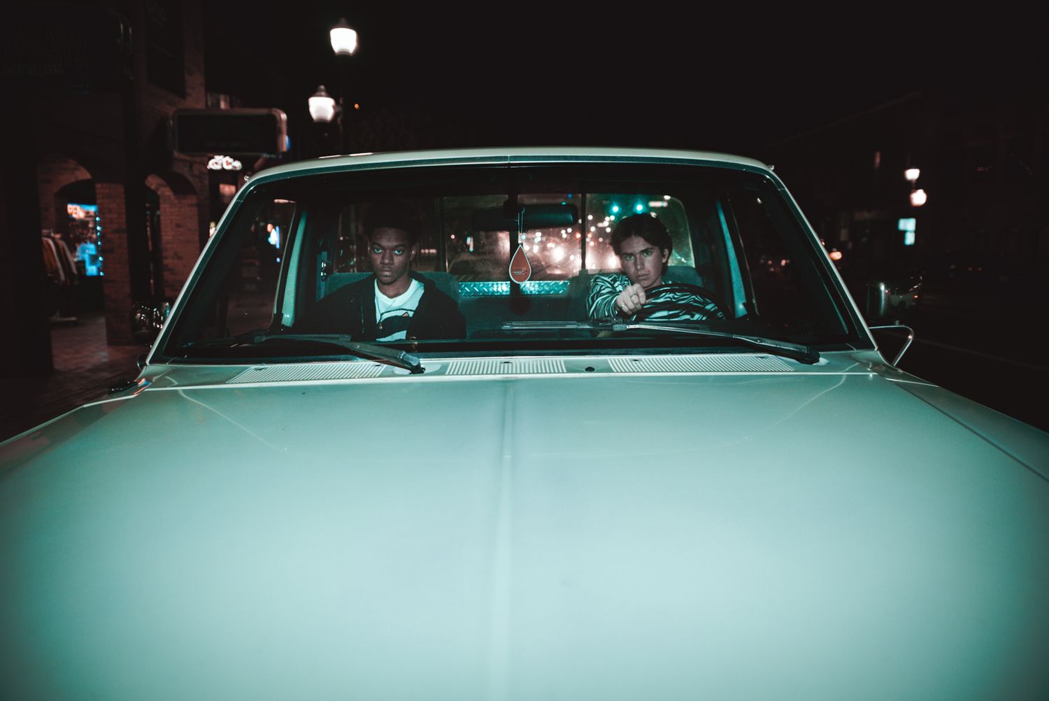 Atmospheric nighttime shot of vintage car with cool teal lighting.
