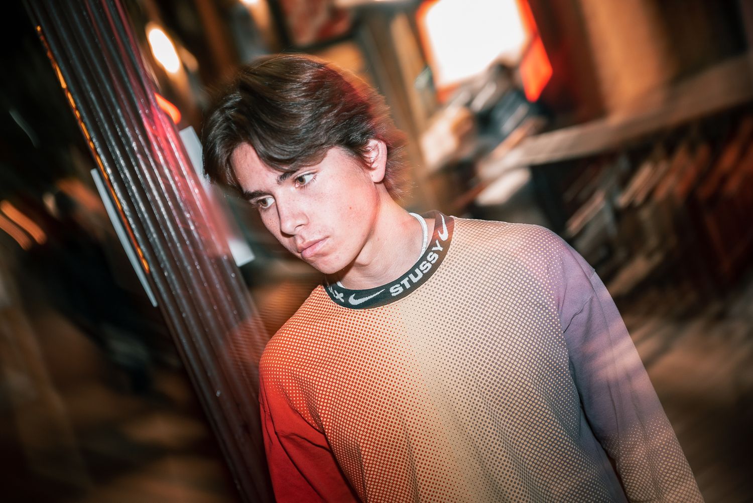 Artistic nighttime portrait with warm street lighting and shallow depth of field.