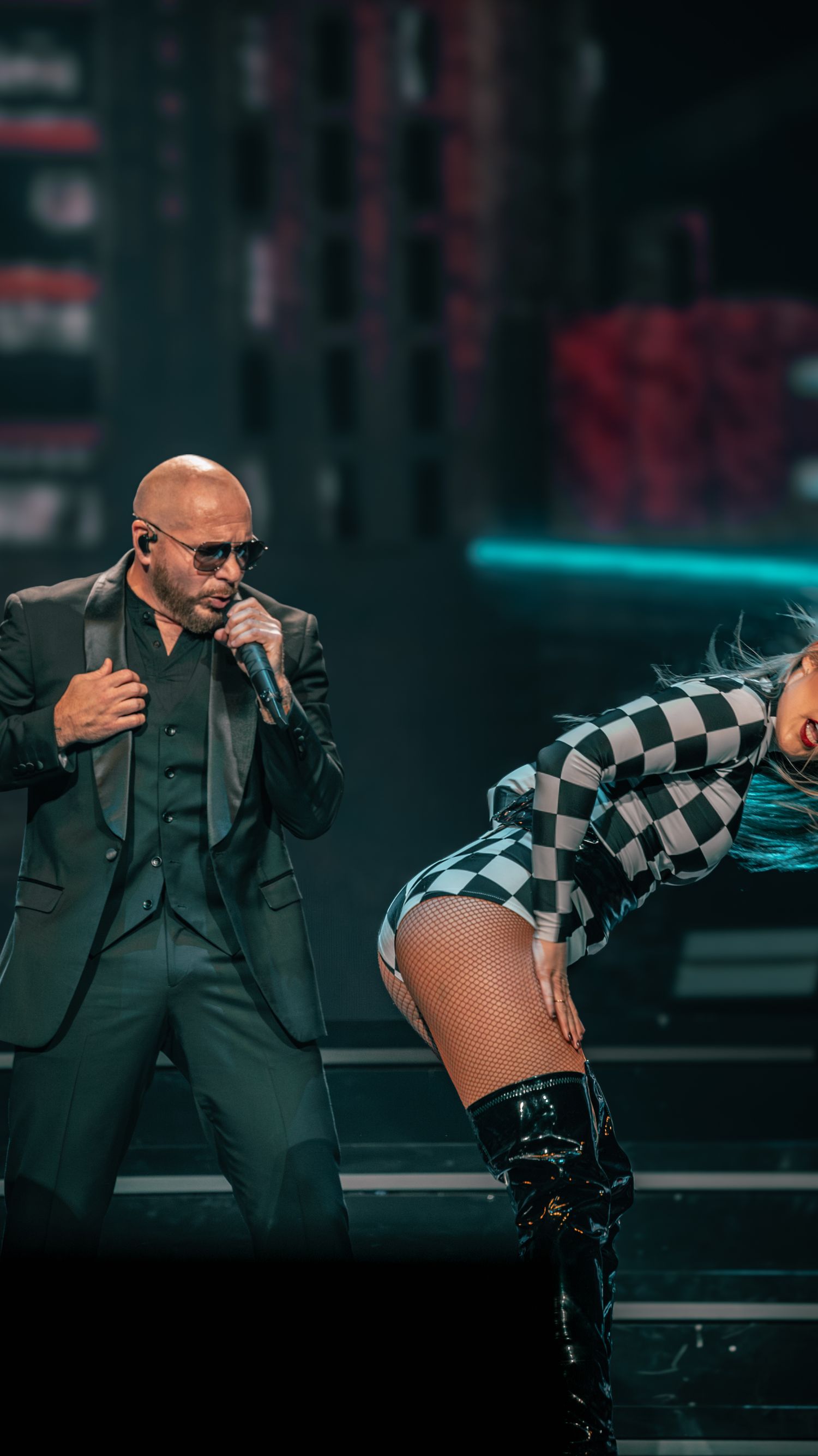 Dynamic stage performance featuring dancers in black and white checkered costumes.